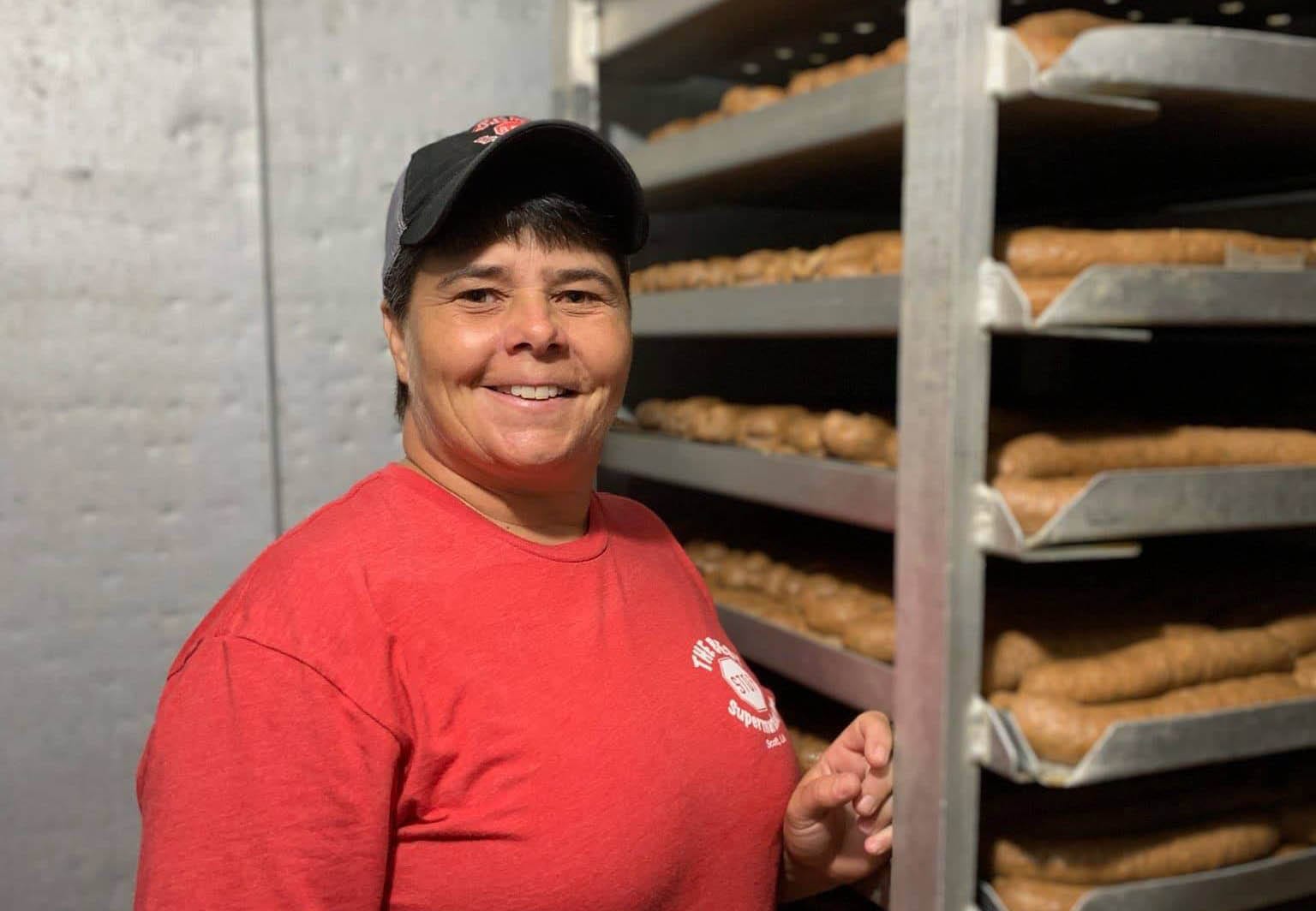 Dana Cormier in front of trays of boudin