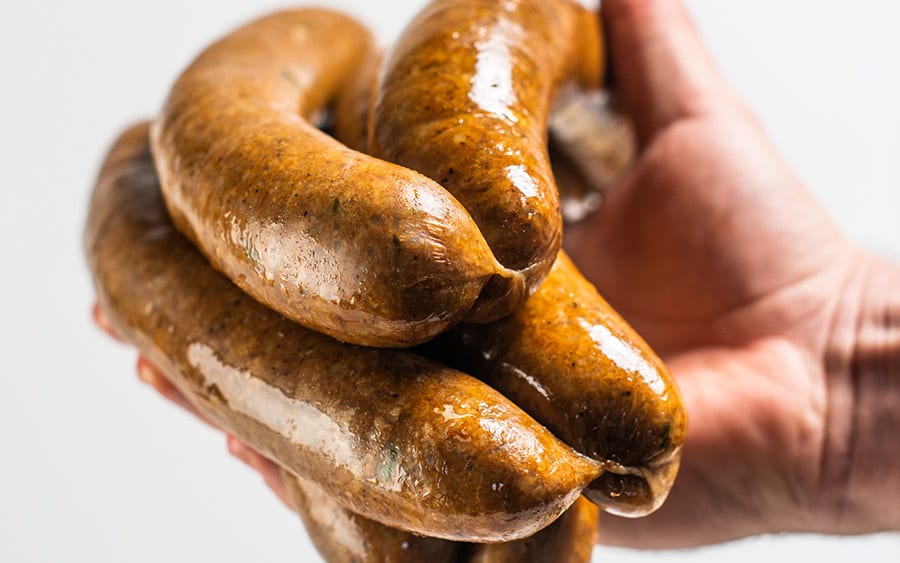 hand holding multiple links of leftover pork boudin