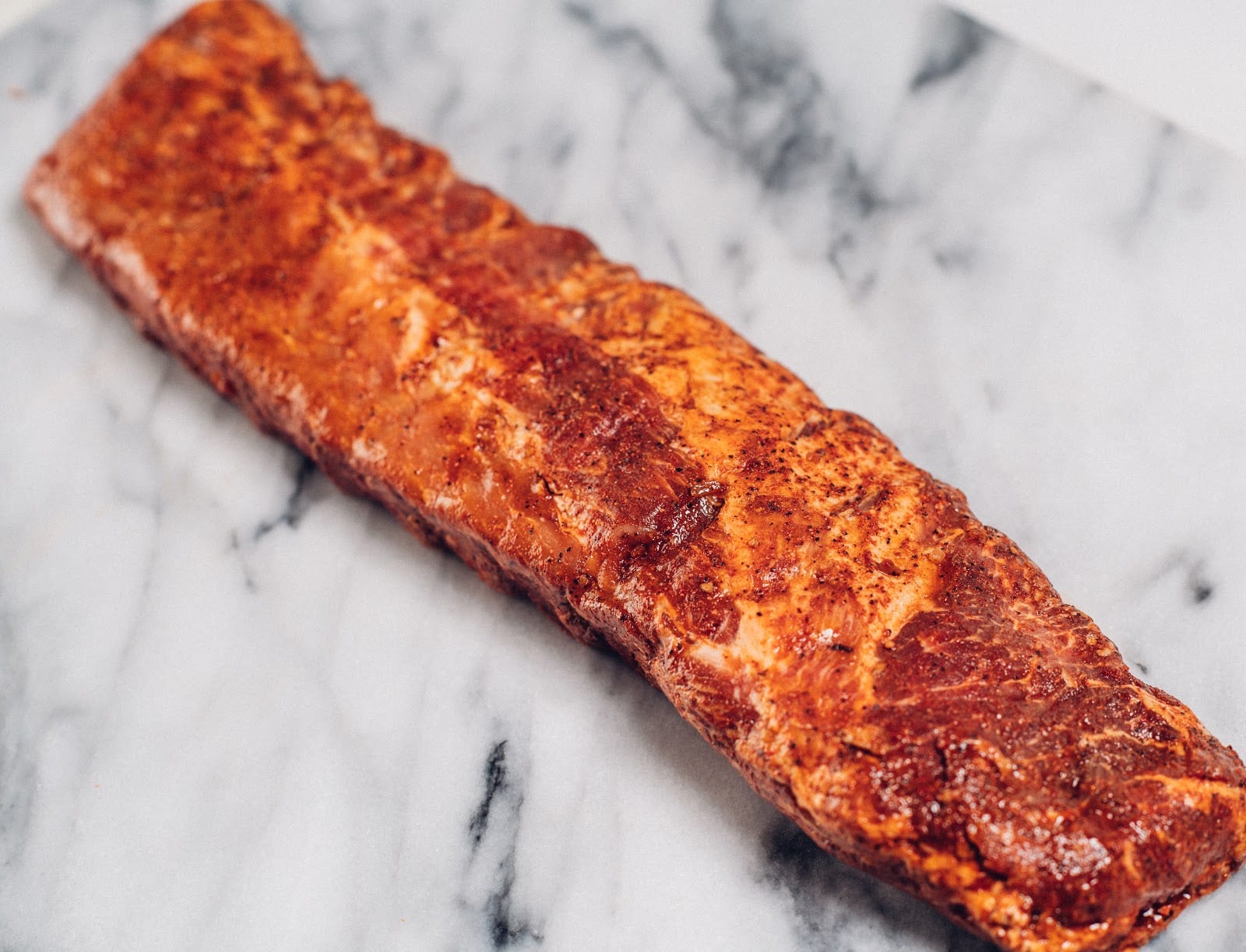 marinated baby back ribs placed on marble countertop