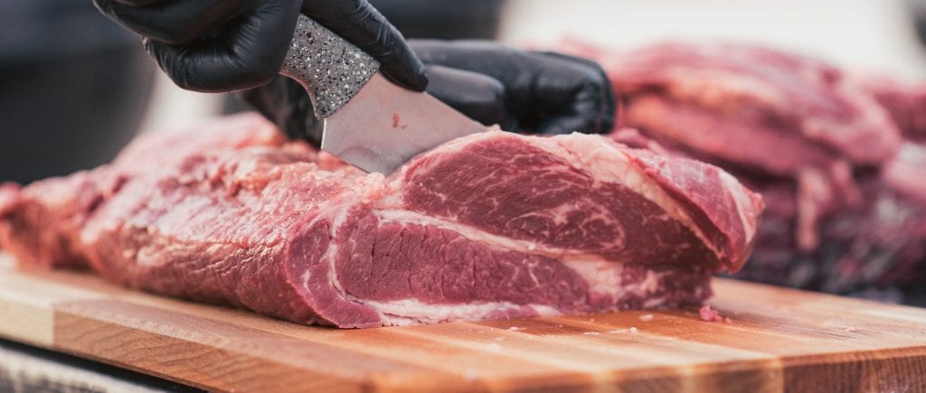 Photo of Meat Butcher Cutting into Chuck Steak